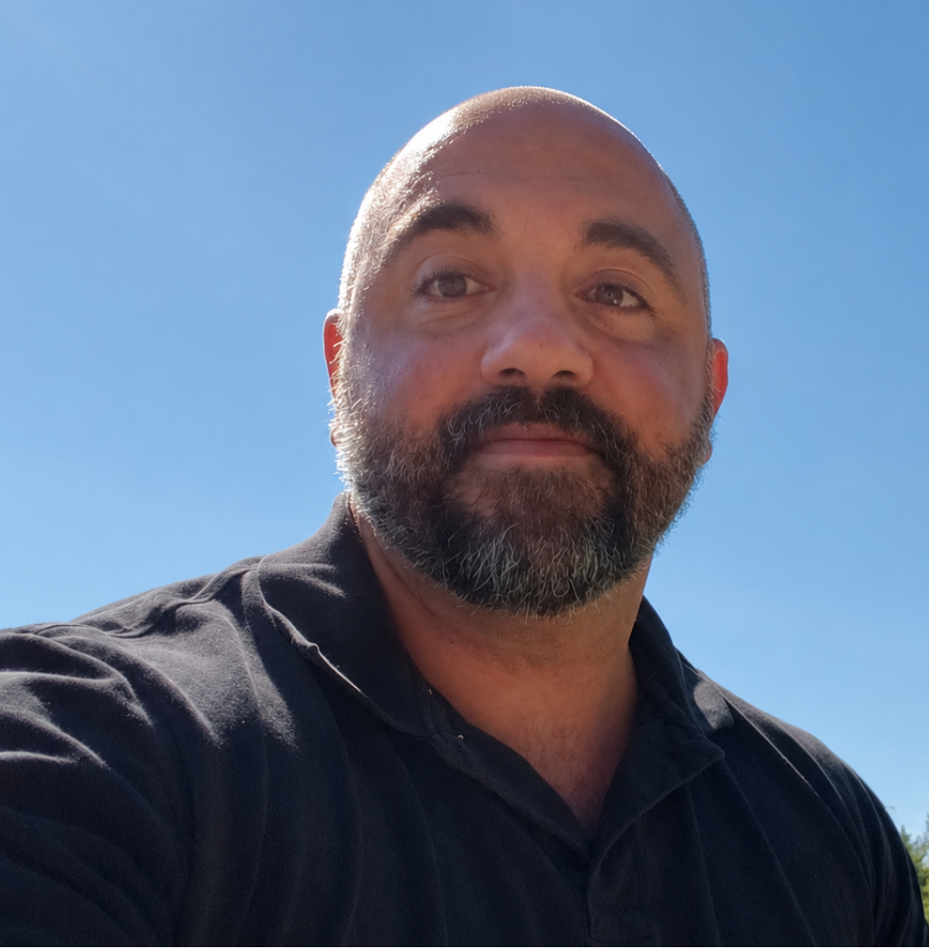 Shawn Cook — a bearded man in a dark shirt, photographed outdoors against an open sky.